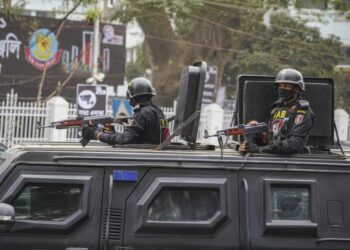 Rapid Action Battalion (RAB) officials stand alert inside a truck in front of Central Shaheed Minar in Dhaka, Bangladesh on February 20, 2021. © 2021 Sipa via AP Images
