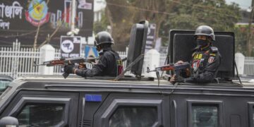 Rapid Action Battalion (RAB) officials stand alert inside a truck in front of Central Shaheed Minar in Dhaka, Bangladesh on February 20, 2021. © 2021 Sipa via AP Images