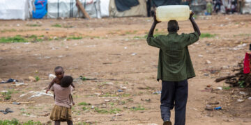 © UNICEF/Karel Prinsloo A man carries water close to Bujumbura in Burundi.