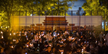 People hold candles in front of a backdrop showing Beijing's Tiananmen Square during a vigil in Hong Kong on June 4, 2018, to mark the 29th anniversary of the 1989 Tiananmen crackdown. Credit: Anthony Wallace/AFP